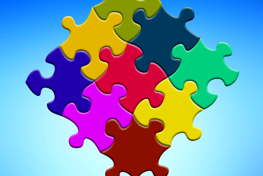 brightly multi-colored puzzle pieces joined together