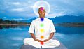 a man sitting in meditation with chakras lit up