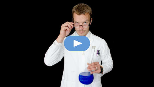 medical practitioner holding a beaker of blue liquid