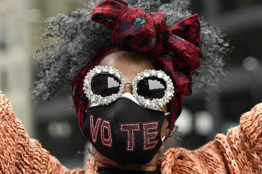 Jackie Simmons wears a mask with a message as she attends the Women’s March in downtown Chicago on Oct. 17, 2020. Dozens of Women’s March rallies were planned from New York to San Francisco to signal opposition to President Donald Trump and his policies. 