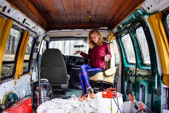 A woman prepares a van that she plans to move into in New Hampshire.  (why some workers are opting to live in their vans)