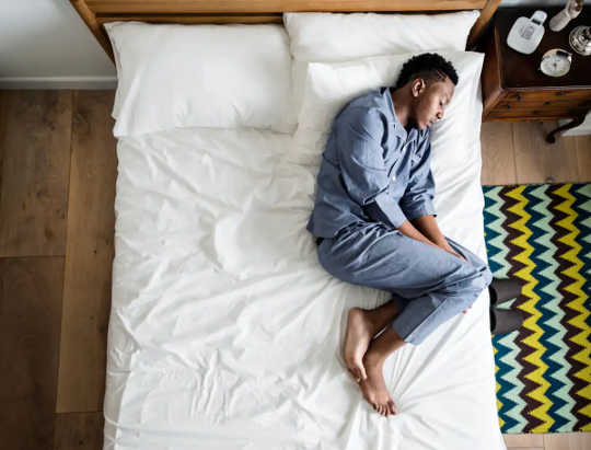 Man lying in bed looking lonely