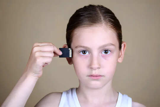 A girl inserting memory chip into her brain.