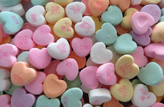 a bunch of heart shaped candies, different pastel colors