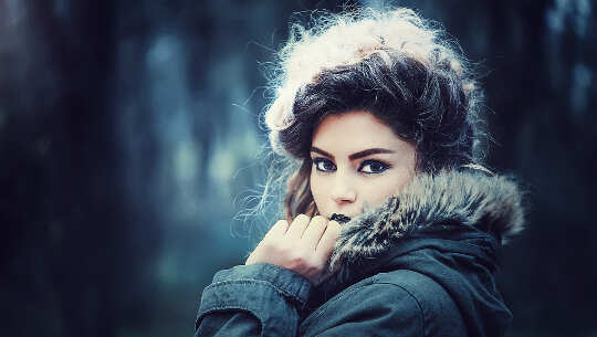 face and shoulders of woman wearing a winter parka and looking at you