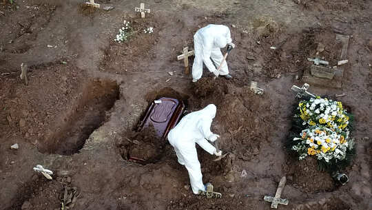 two gravediggers with open graves