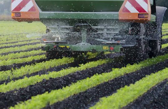 Farm machinery spreading fertiliser, which is a major source of agriculture emissions. 