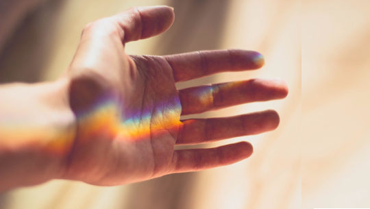 a rainbow in the palm of an open hand