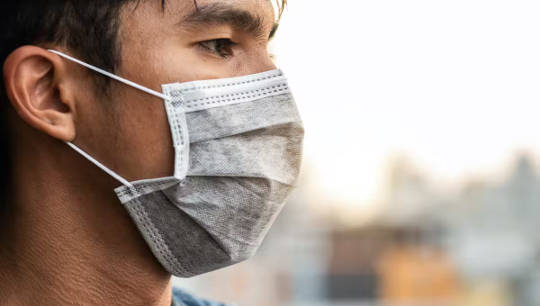 picture of person wearing a surgical mask which does not seal around the edges
