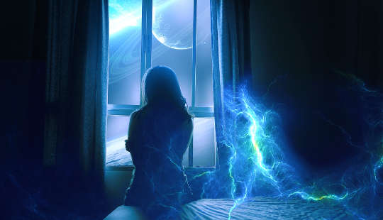woman sitting on a  bed looking outside