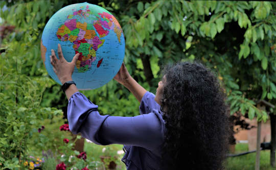 woman holding up a globe of the planet