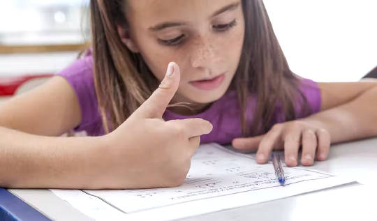 a child doing math homework and counting on her fingers