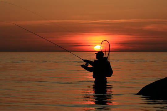 Man taking a "time-out" by fishing at sunset