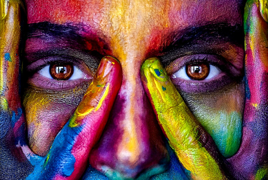 a face covered with various bright and vibrant colors
