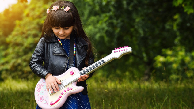 young girl with flowers in her hair playing an electric guitar