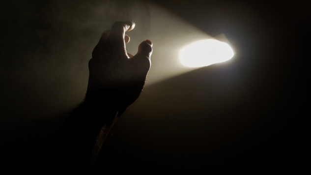 a hand reaching towards a light