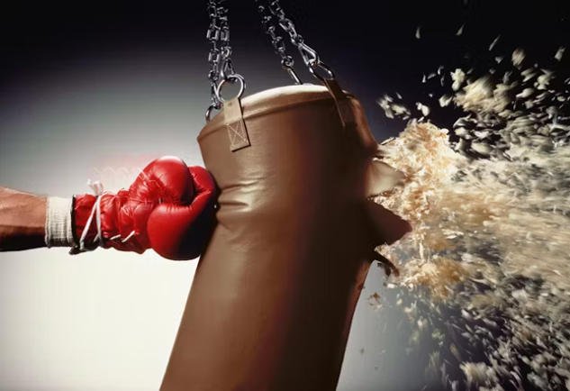 someone wearing boxing gloves hitting a punching bag