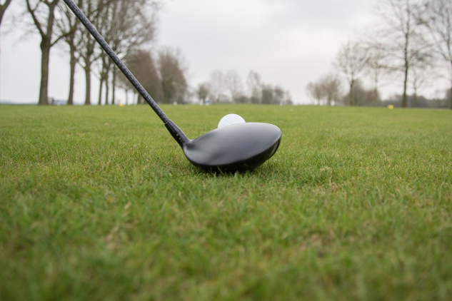 a close-up of a golf club set right in front of a golf ball