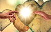 two hands reaching out to each other in front of a brightly shining heart