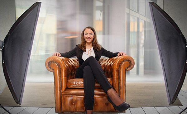 young woman sitting comfortably and confidently in an arm chair