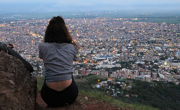 een vrouw zit met uitzicht op een stad