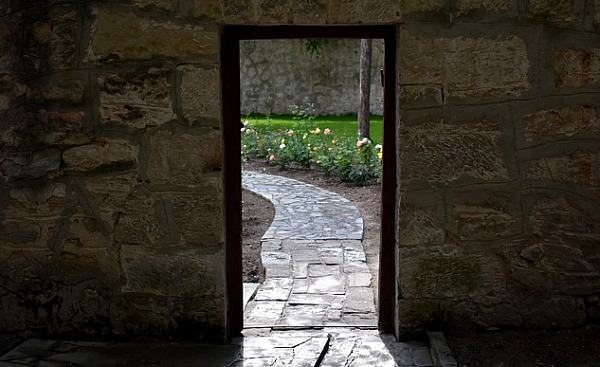 en dörr som öppnar sig mot en pastoral scen