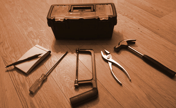盒子周圍散佈著 5 個工具：記事本、螺絲起子、鋼鋸、鉗子、鐵鎚
