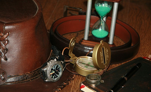 an hourglass, a compass, a pen, and a notebook