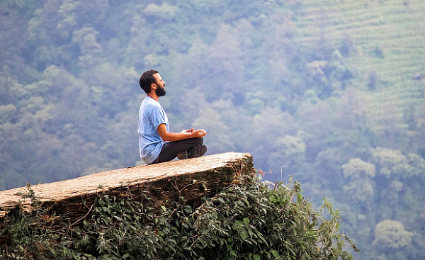 mies istuu meditaatiossa