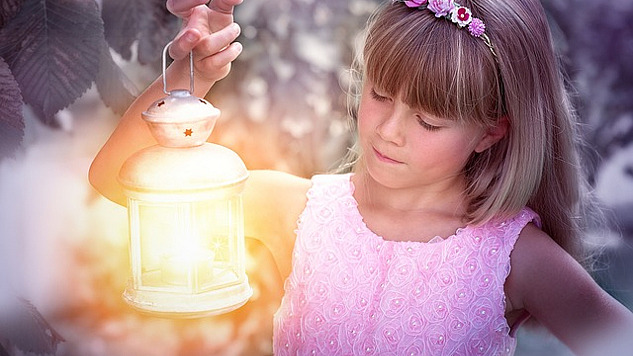 a girl holding up a brightly shining lantern