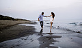 man and woman walking on the beach holding hands