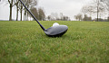 a close-up of a golf club set right in front of a golf ball