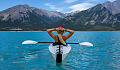 woman sitting and relaxing in a kayak in the middle of a lake