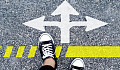 feet on a road with 3 arrows pointing left, right and straight ahead