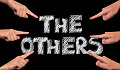 hands pointing to the words "The Others"