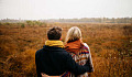 couple looking out at a bare grassy field