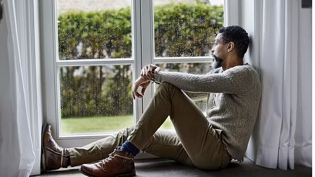 man sitting looking outside the window