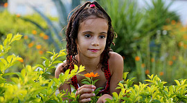young girl in a field of plants and flowers