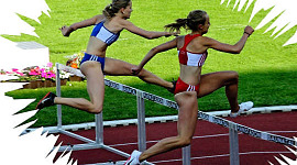two women track runners jumping a hurdle