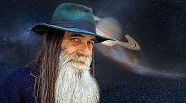 older long bearded man standing in front of a starry sky and planet