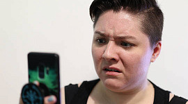 woman looking at her phone with a look of disgust on her face