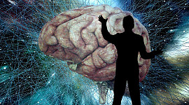 a silhouette of a man standing in front of a huge brain