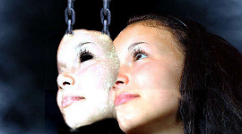 a mask held up by chains overlapping a woman's face